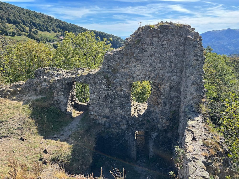 Photo des ruines du château de Freundstein, avec la ferme-auberge du Freundstein qui apparaît dans le fond.