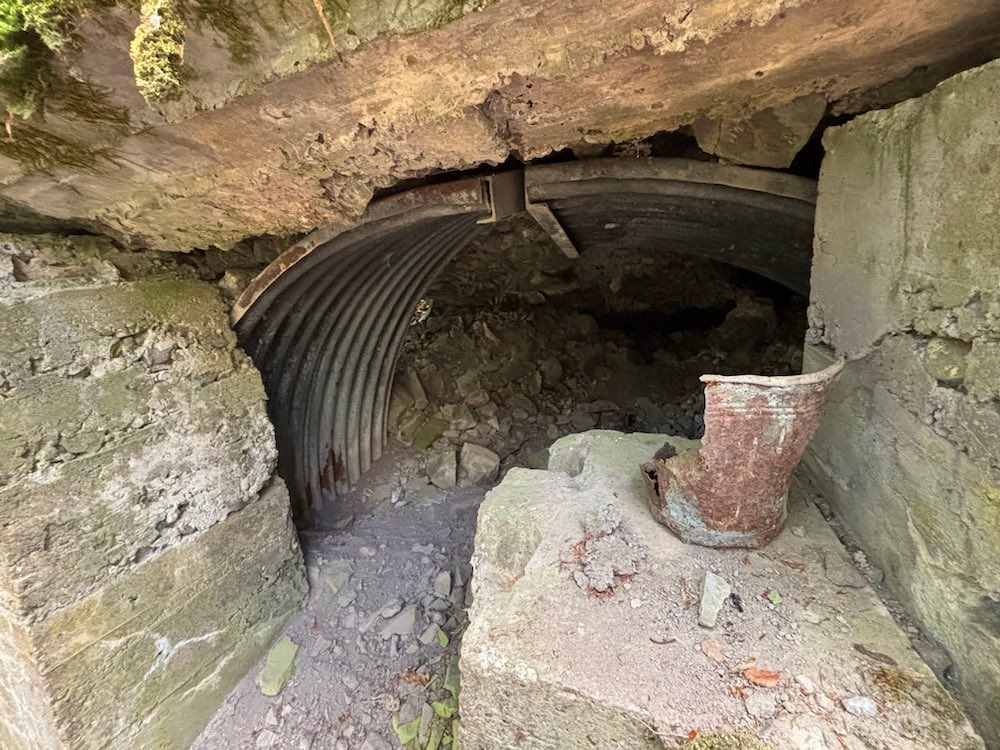 L'intérieur d'un blockhaus allemand effondré, avec un vieux sceau de l'époque 14-18 posé à l'entrée.